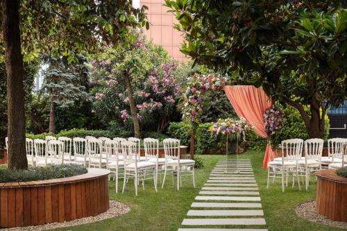 a row of chairs and an umbrella in a garden at Sheraton Istanbul Levent in Istanbul