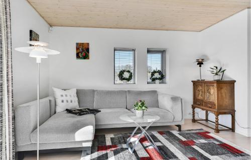 a living room with a gray couch and a table at Awesome Home In Skårup Fyn With 4 Bedrooms in Oure