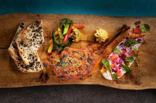 a cutting board with meat and vegetables on it at JW Marriott Marquis Hotel Dubai in Dubai