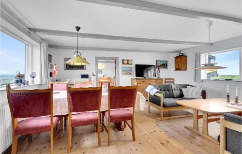 a kitchen and living room with a table and chairs at 3 Bedroom Awesome Home In Løkken in Løkken
