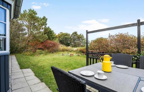 a table with a yellow tea kettle on a patio at Holiday Home Ildervej Hemmet Denmark in Hemmet