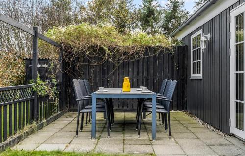 a table and chairs on a patio with a fence at Holiday Home Ildervej Hemmet Denmark in Hemmet