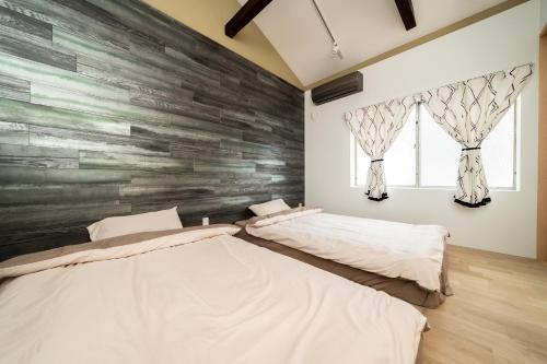 two beds in a room with a stone wall at 三十三Mizu in Kyoto