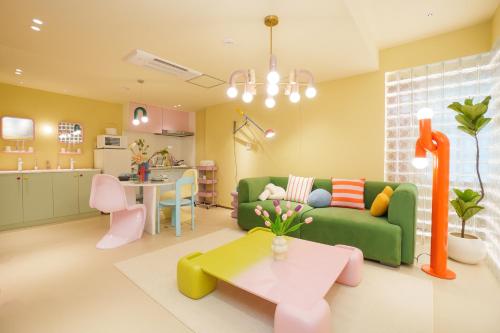 a living room with a green couch and a table at 寅ホテル 御徒町 TORA HOTEL Okachimachi in Tokyo
