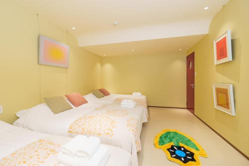 two twin beds in a room with two towels at 寅ホテル 御徒町 TORA HOTEL Okachimachi in Tokyo