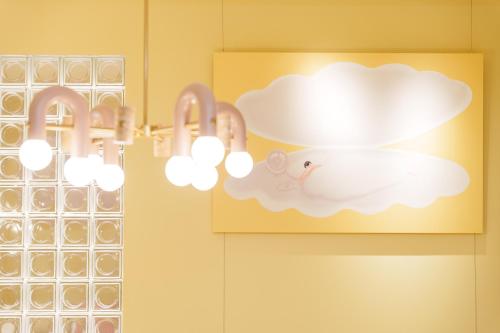 a bathroom with two lights on a wall at 寅ホテル 御徒町 TORA HOTEL Okachimachi in Tokyo