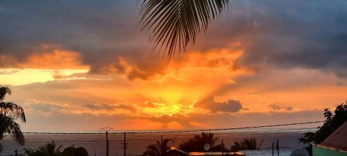 a sunset over the ocean with a cloudy sky at Villa Rosie in Sainte-Rose