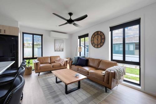 a living room with two couches and a ceiling fan at Cottage Myrtleford in Myrtleford