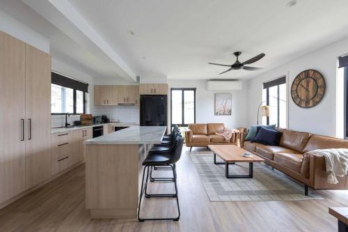 a kitchen and living room with a couch and a table at Cottage Myrtleford in Myrtleford