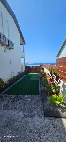 a backyard with a green lawn next to a building at Villa Rosie in Sainte-Rose