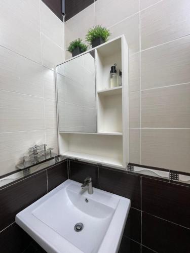 a bathroom with a sink and a mirror at Homestay & Pool Laman Sri Aman Pontian in Pontian Besar