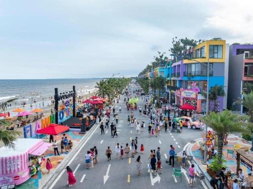 a crowd of people walking on a street near the beach at Flamingo Hai Tien in Hoằng Hóa