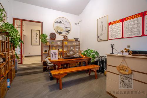 a room with a wooden table and a bench at 建水县井宿客栈 in Jianshui