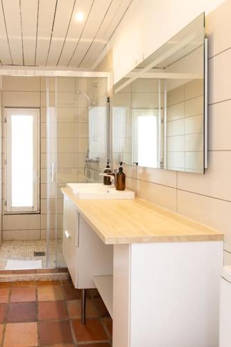 une salle de bain avec un lavabo et un miroir dans l'établissement Maison au calme, à deux pas du port et des plages, au Croisic
