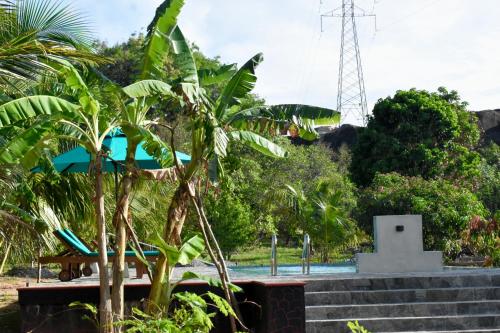 a resort with a pool and trees and a tower at Green Hut Nature Resort in Sigiriya