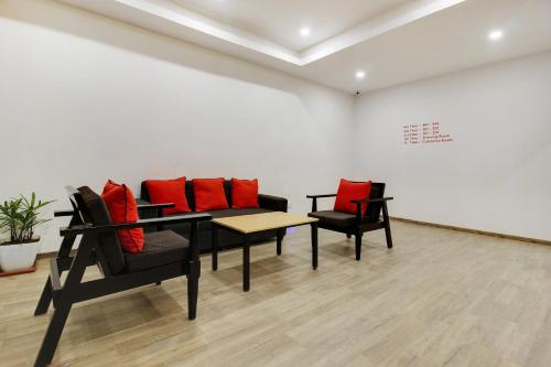 a room with two chairs and a table with red pillows at Super townhouse moosapet Rcc Prime in Hyderabad
