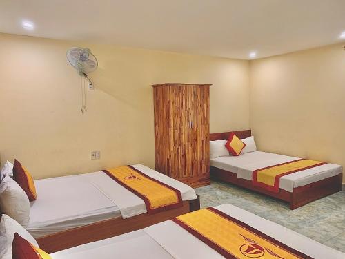 a bedroom with two beds and a fan at Huong Cang Sea View Hotel in Cat Ba