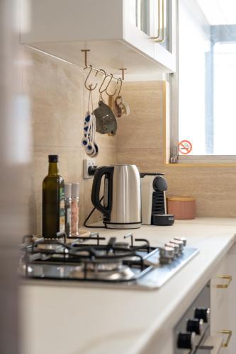 a kitchen counter with a stove top with a tea kettle at Little Kintore City Escape in Thebarton