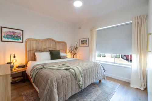 a bedroom with a large bed and a window at Little Kintore City Escape in Thebarton