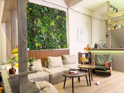 a living room with a couch and a green wall at Bangkok Neighborhood Hostel in Bangkok