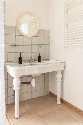 une salle de bain avec un lavabo blanc et un miroir dans l'établissement Maison au coeur du Croisic idéalement placée !, au Croisic