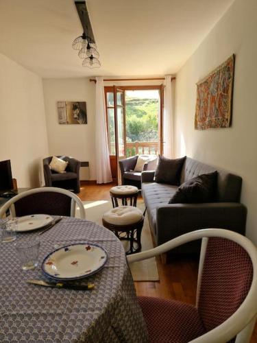 un salon avec une table et un canapé dans l'établissement Maison Vidal, au pied de l'Aubrac, à Coubisou