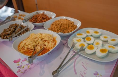 a table topped with bowls of eggs and other food at Regale Motel in Zhonghe