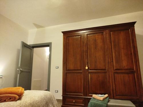 a bedroom with a large wooden cabinet next to a bed at La Chioma di Berenice in Celano