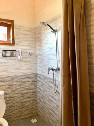 a bathroom with a shower with a glass door at Bagus Homestay in Ubud