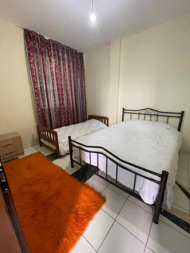 a bedroom with two beds and a red curtain at Bajovah Apartments & Restaurant in Tirana