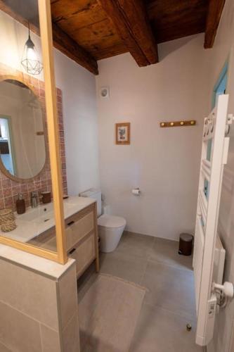 a bathroom with a sink and a toilet and a mirror at Route des vins - 4 pers - pied des Vosges in Barr