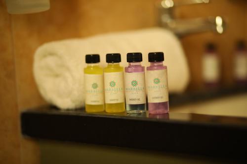 three bottles of essential oils sitting on a table at Marbella Beach Hotel in Golem
