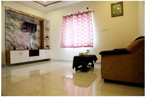 a living room with a couch and a table at Padmavathi Homestay -2BHK 1BHK AC Apartments for group of families - Best location - Flyover to Alipiri gate - Walk to PS4 Veg Restaurant - Modular Kitchen - Super fast Wi-Fi- Near to Tirupati Bus Stand 2 KM-Near to Railway Station 2KM in Tirupati