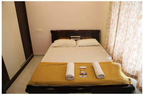 a bed in a room with towels on it at Padmavathi Homestay -2BHK 1BHK AC Apartments for group of families - Best location - Flyover to Alipiri gate - Walk to PS4 Veg Restaurant - Modular Kitchen - Super fast Wi-Fi- Near to Tirupati Bus Stand 2 KM-Near to Railway Station 2KM in Tirupati