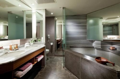ein Bad mit einem Waschbecken und einer Dusche in der Unterkunft CHECK inn Select Taipei Yamgmingshan in Taipeh