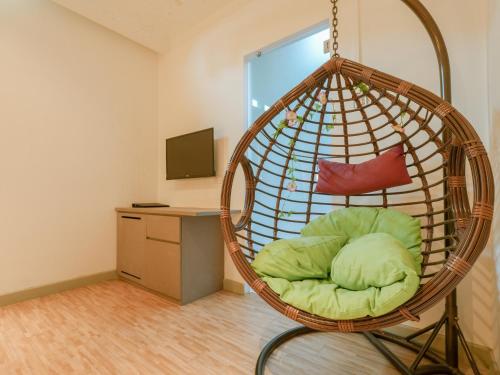 a room with a rattan hanging chair with a bed at A Hotel Joo Chiat in Singapore