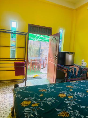 a bedroom with a bed and a door and a table at Pick Me Village in Dambulla