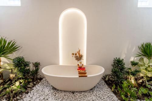 ウルワツにあるUlu Villaの植物のある部屋にある白い浴槽