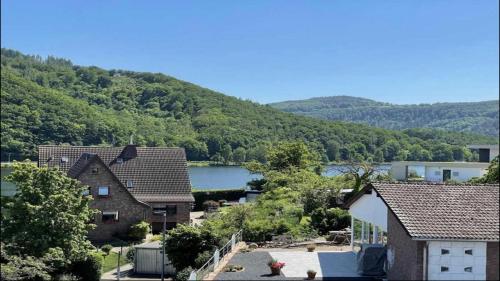 a view of a house with a lake and mountains at Green Seeblick Hotel am See in Obermaubach