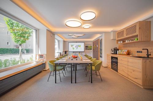 a kitchen and dining room with a table and chairs at Das Grüne Hotel zur Post - 100 % BIO in Salzburg