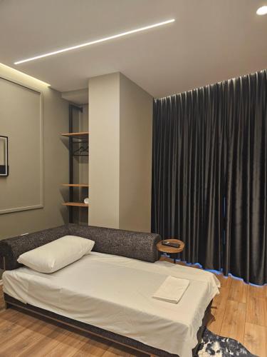 a bedroom with a bed and a large window at Tirana Apartment KDK in Tirana