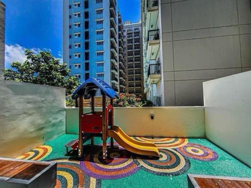 a playground with a slide and an umbrella on a roof at The Palladium Iloilo City in Iloilo City