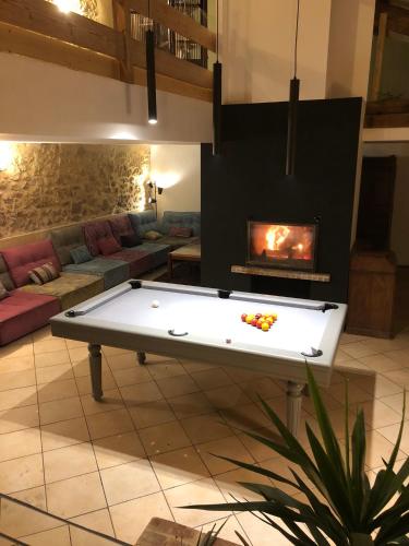 - un salon avec un billard et une cheminée dans l'établissement Villa Baptiste Spa Sauna Billard Piano ping-pong baby-foot Piscine près de Bordeaux, à Cérons
