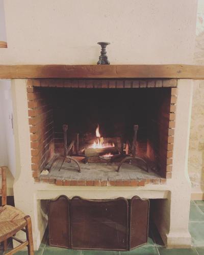 d'une cheminée en briques avec une cheminée. dans l'établissement Villa Baptiste Spa Sauna Billard Piano ping-pong baby-foot Piscine près de Bordeaux, à Cérons