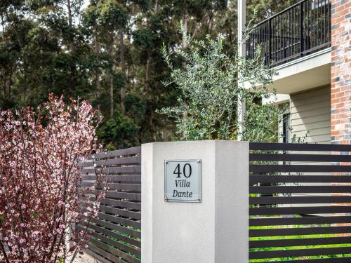 a sign on a fence in front of a house at Villa Dante - walk to town - brand new town house in Margaret River Town