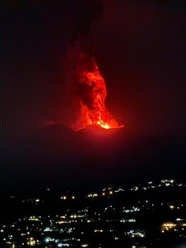 a fire volcano in the sky at night at Humboldt Luxury Rooms Taormina in Taormina
