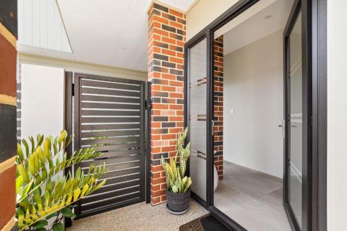 a pivot door in a house with plants at Villa Dante - walk to town - brand new town house in Margaret River Town