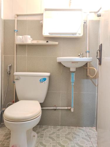 a bathroom with a toilet and a sink at Soben Cafe Guesthouse & Restaurant in Siem Reap