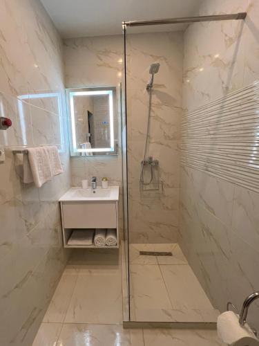 a bathroom with a shower and a sink at Hotel DAMAD in Smîrdan
