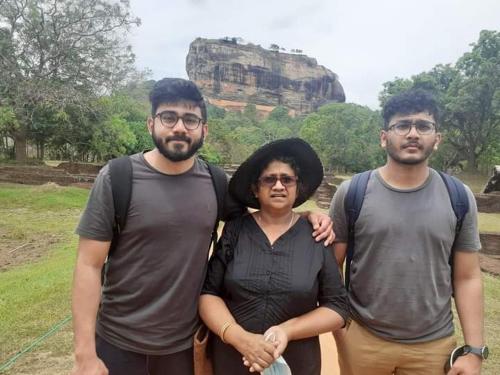 a woman and two men standing in front of a mountain at Rohan's Residence in Kandana
